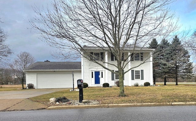 view of front of property featuring a front yard, concrete driveway, and an attached garage