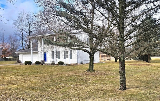 view of side of property featuring a garage and a yard