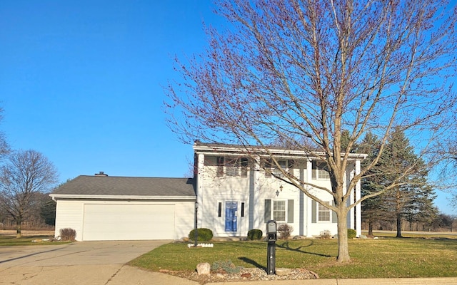 greek revival house with driveway, a front yard, and an attached garage