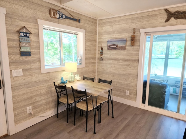 dining space with wood walls and hardwood / wood-style floors