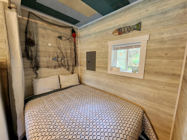 bedroom featuring electric panel and wood walls