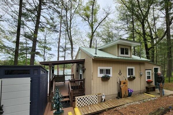 rear view of house with a deck and an outdoor structure