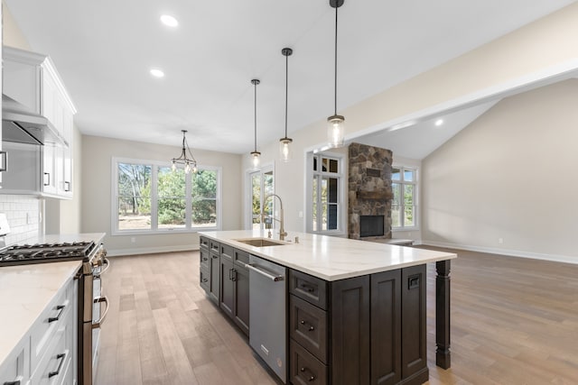 kitchen featuring light wood-type flooring, stainless steel appliances, white cabinetry, and sink