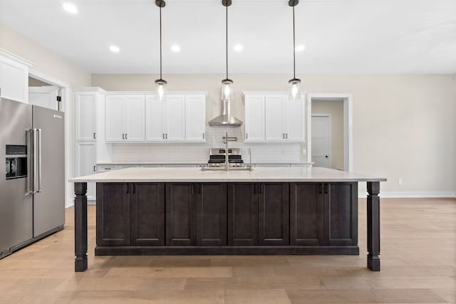 kitchen with a kitchen breakfast bar, a center island with sink, hanging light fixtures, and appliances with stainless steel finishes