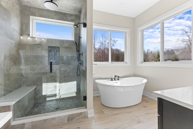 bathroom featuring hardwood / wood-style floors, shower with separate bathtub, and a wealth of natural light