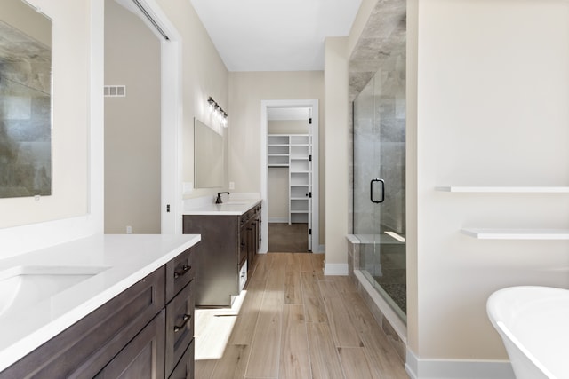 bathroom with hardwood / wood-style flooring, vanity, and shower with separate bathtub