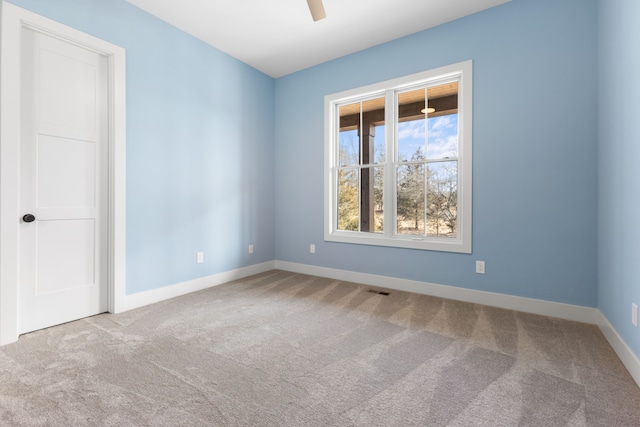 carpeted spare room with ceiling fan