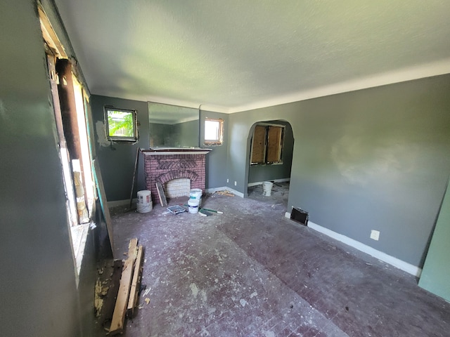 unfurnished living room with a fireplace and a textured ceiling