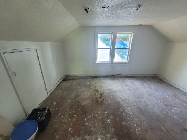 bonus room featuring hardwood / wood-style flooring, lofted ceiling, and a textured ceiling