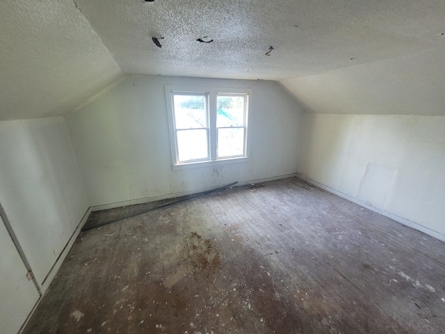 bonus room featuring hardwood / wood-style floors, a textured ceiling, and vaulted ceiling