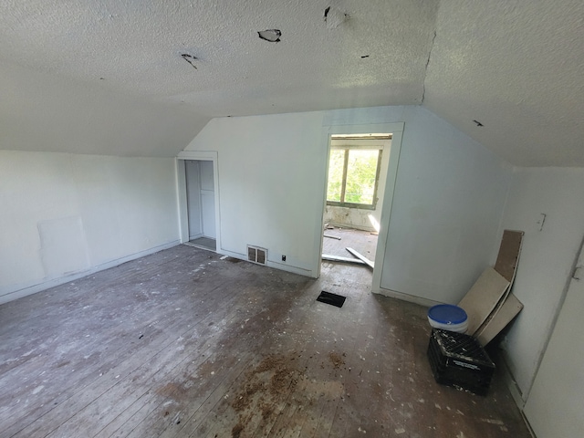 bonus room with dark hardwood / wood-style floors, a textured ceiling, and vaulted ceiling