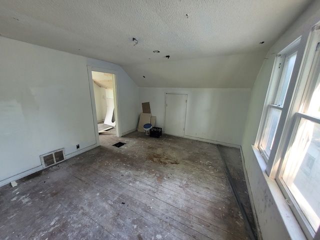 bonus room featuring a textured ceiling, plenty of natural light, and vaulted ceiling