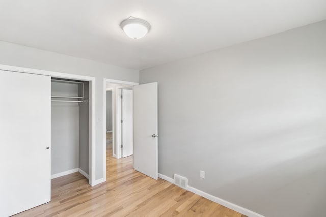 unfurnished bedroom featuring a closet and light wood-type flooring