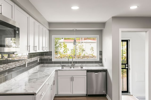 kitchen with plenty of natural light, white cabinetry, and stainless steel appliances