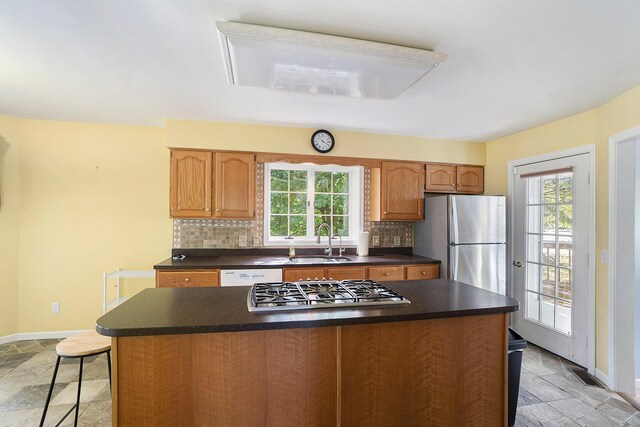 507 Lena Dr, South Haven, MI 49090 - kitchen featuring stone tile floors, a sink, stainless steel appliances, and tasteful backsplash