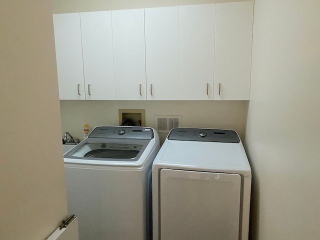 laundry area with cabinets and washing machine and clothes dryer