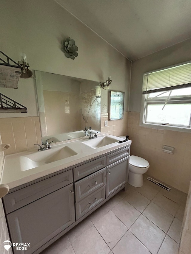 bathroom with tile patterned flooring, vanity, tile walls, and toilet