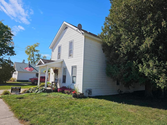 view of side of property featuring a porch and a yard