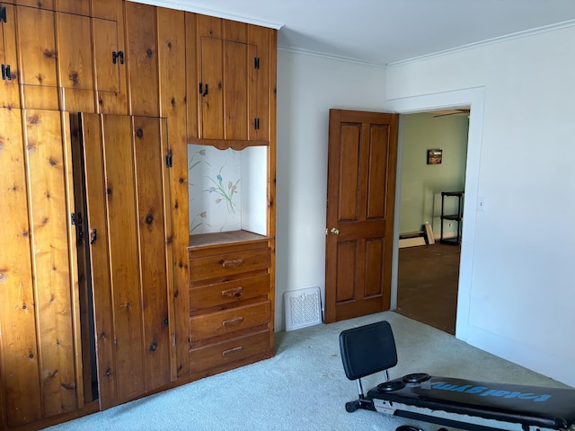 exercise area with crown molding and light carpet