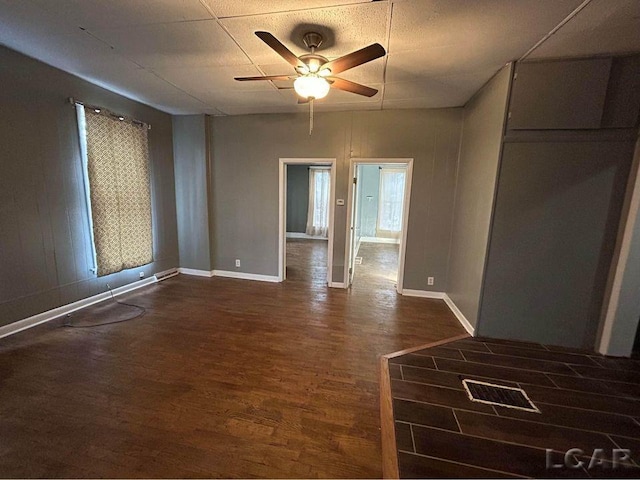 unfurnished room with ceiling fan and dark wood-type flooring