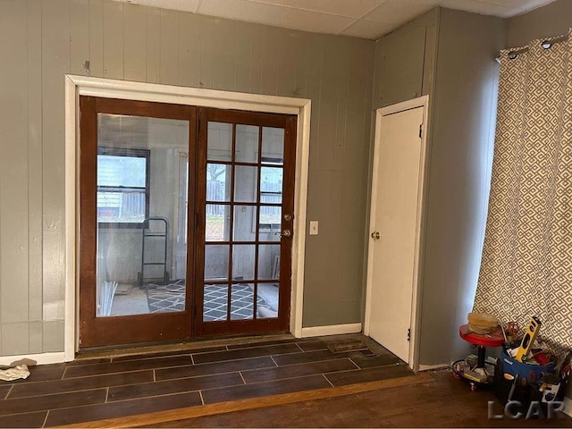 entryway featuring wood walls and french doors