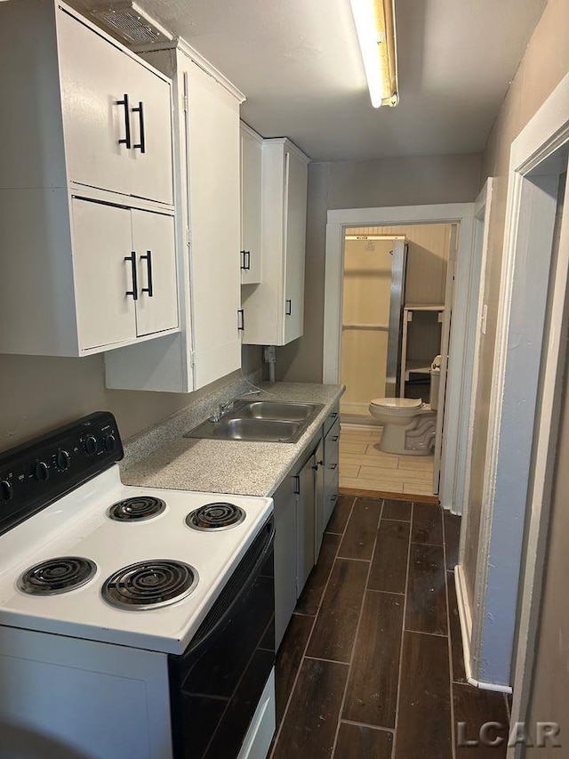 kitchen featuring white cabinets, white electric range, and sink