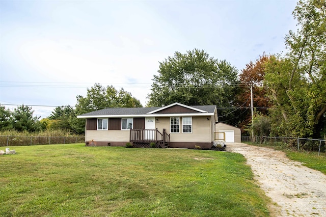 view of front of house featuring a garage, a front lawn, and an outdoor structure