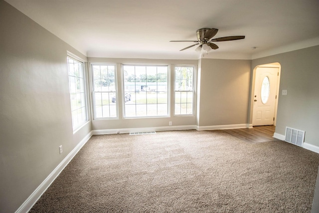 7029 Silver Lake Rd, Linden, MI 48451 - unfurnished room with carpet floors, a ceiling fan, and arched walkways