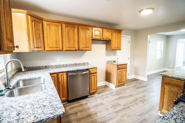 7029 Silver Lake Rd, Linden, MI 48451 - kitchen with stainless steel dishwasher, brown cabinets, light wood finished floors, and light stone countertops
