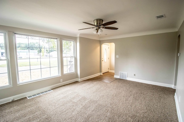 7029 Silver Lake Rd, Linden, MI 48451 - spare room with arched walkways, carpet floors, and a ceiling fan