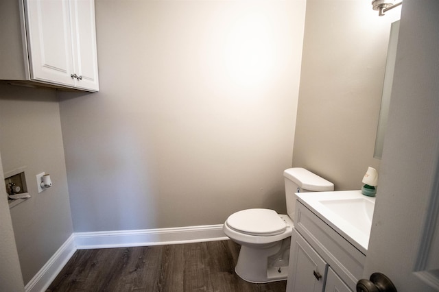 bathroom featuring wood-type flooring, toilet, and vanity