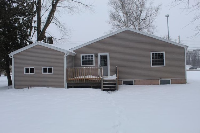 snow covered rear of property featuring a deck