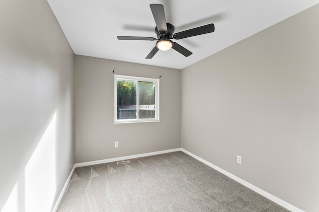 carpeted spare room featuring ceiling fan