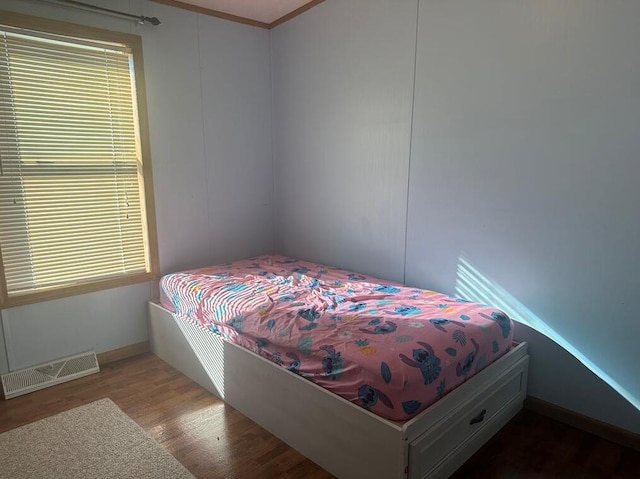 bedroom featuring hardwood / wood-style floors and crown molding