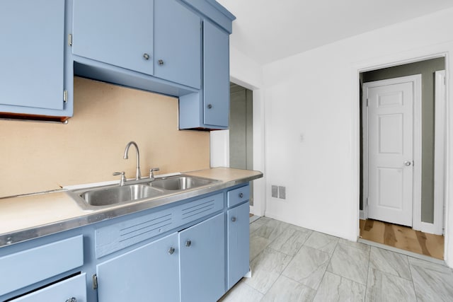 kitchen featuring blue cabinetry and sink