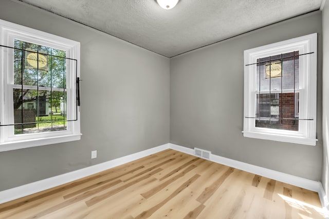 empty room featuring light hardwood / wood-style floors and a textured ceiling