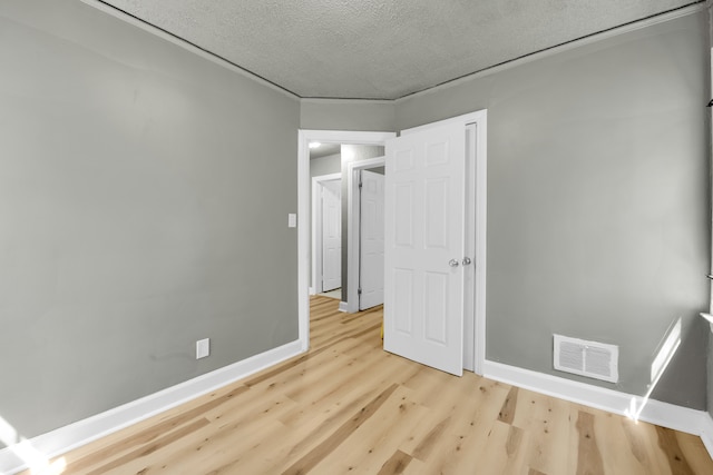 unfurnished bedroom featuring light hardwood / wood-style flooring and a textured ceiling