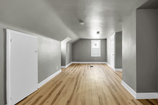 bonus room with light hardwood / wood-style flooring and lofted ceiling