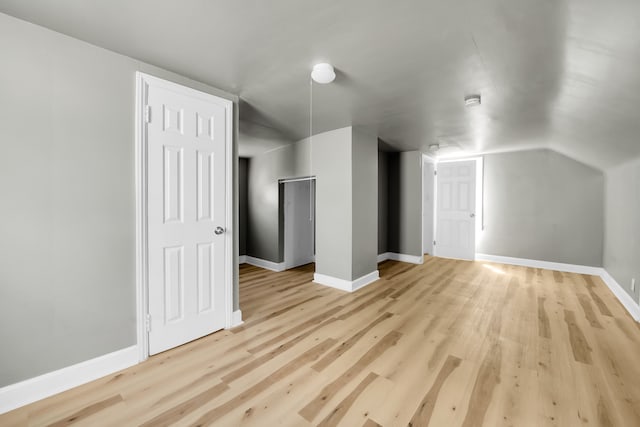 bonus room with lofted ceiling and light wood-type flooring