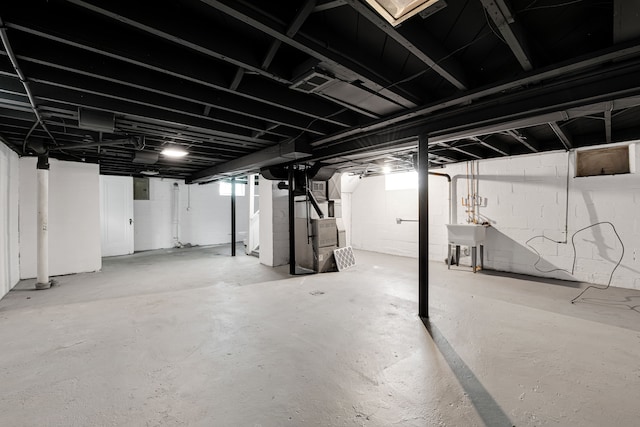 basement featuring heating unit and sink