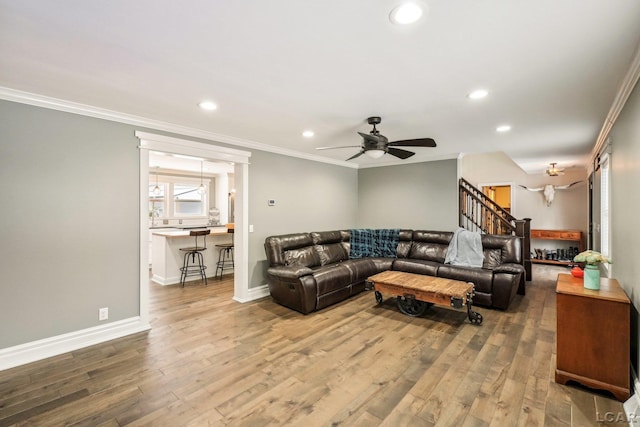 living room featuring crown molding, hardwood / wood-style flooring, and ceiling fan