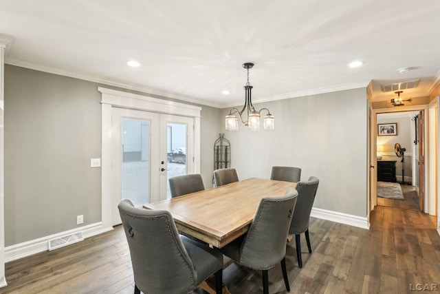 dining room with ornamental molding, dark hardwood / wood-style floors, an inviting chandelier, and french doors