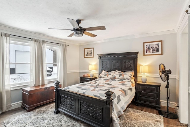 bedroom with ceiling fan, wood-type flooring, ornamental molding, and a textured ceiling