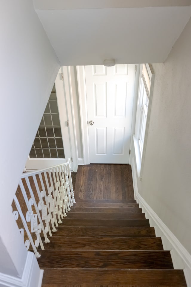 stairs featuring hardwood / wood-style floors