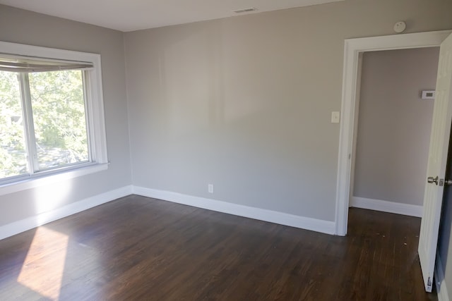 empty room with dark hardwood / wood-style flooring