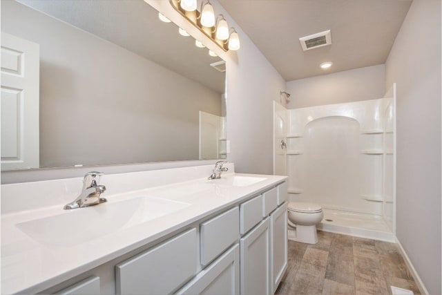 bathroom with a shower, vanity, and toilet