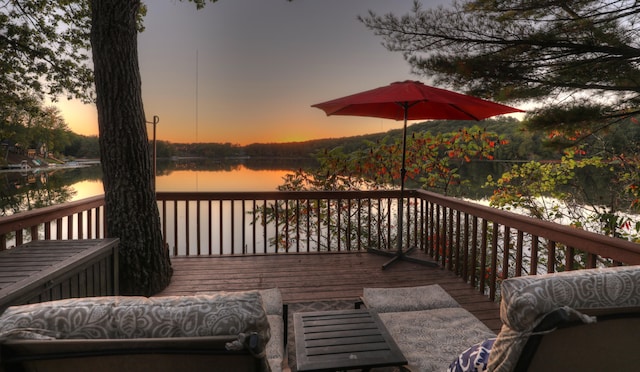 deck with an outdoor living space and a water view