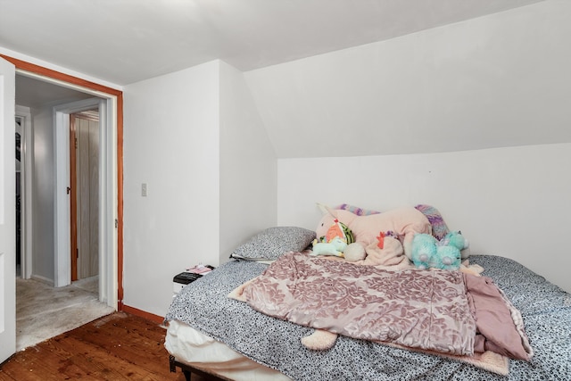 bedroom with vaulted ceiling and dark wood-type flooring