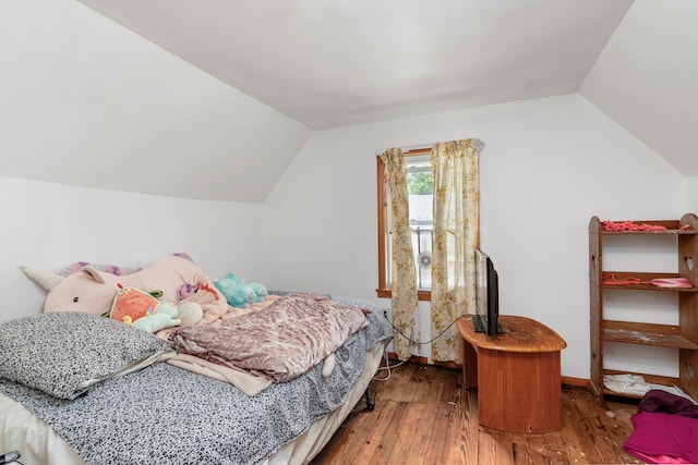 bedroom featuring hardwood / wood-style flooring and vaulted ceiling