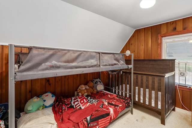 bedroom with lofted ceiling and wood walls